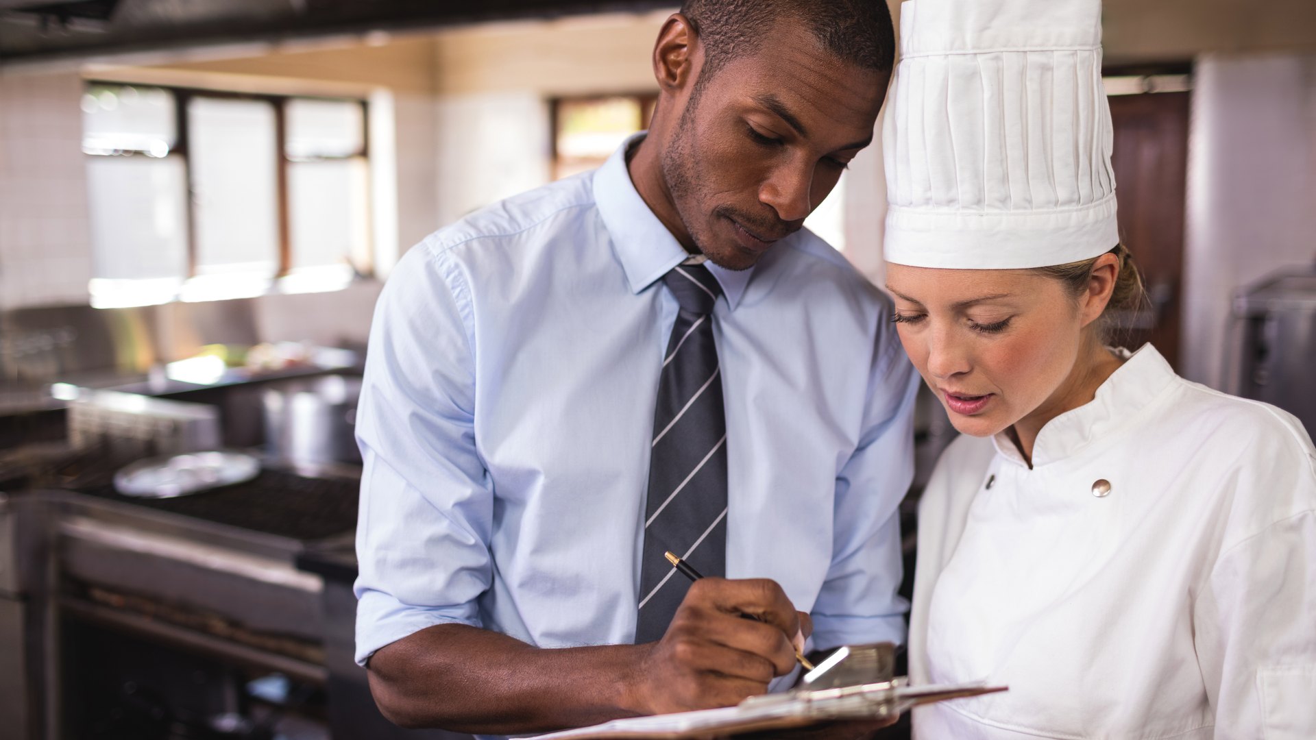 Coste de personal en restaurantes: responsable y jefa de cocina revisando el equipo con el cuadrante