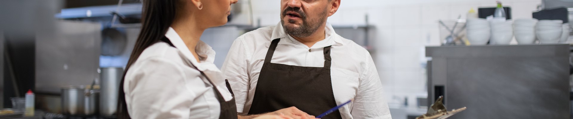 Jefe de cocina y cocinero repasando la carta y la plantilla