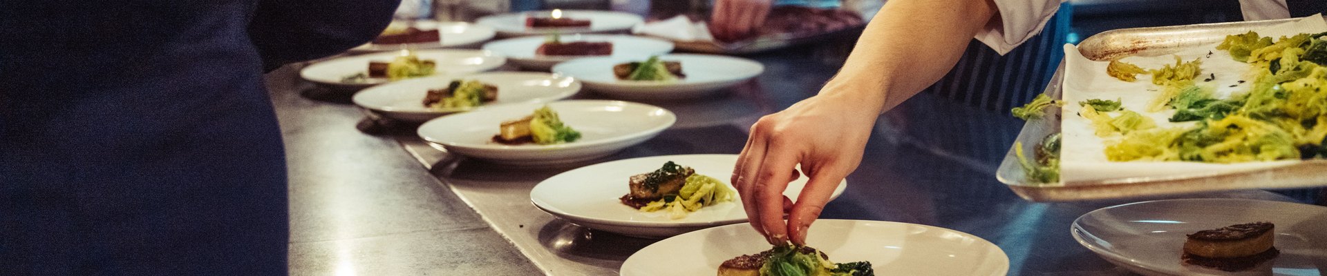 Cocina de restaurante emplatando el menú del día en pleno servicio